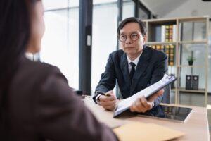 An employment lawyer meets with a client to review workplace concerns and discuss how to sue an employer in California.