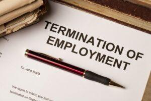 A termination of employment letter sits on a desk with a pen and glasses. Such a letter may provide useful information when reviewing whether an employee was wrongfully fired under California law.