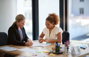 A lawyer sitting at a table with a client, explaining whether short-term disability covers maternity leave.